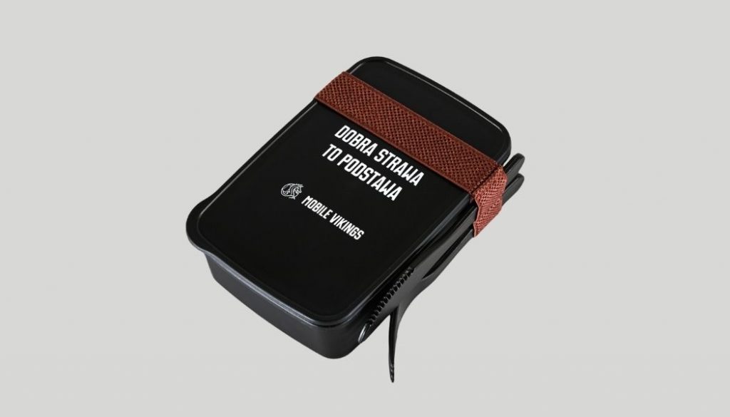 Mały lunchbox w kolorze czarnym z białym napisem, widelcem i nożem w zestawie umieszczone na blogu Mobile Vikings.