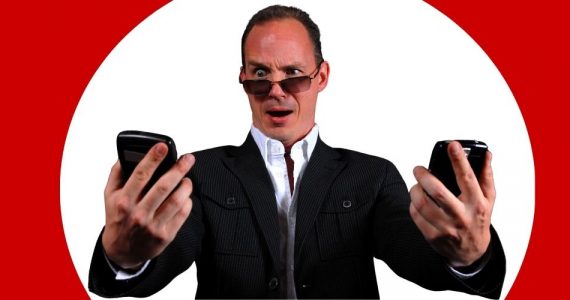 Mężczyzna patrzy na dwa telefony dwie karty SIM