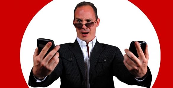 Mężczyzna patrzy na dwa telefony dwie karty SIM