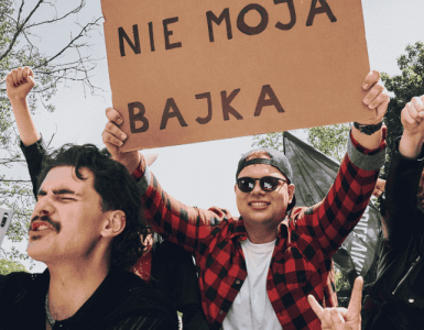 Grupa radosnych osób manifestuje radość z rozwiązania umowy z telefonią komórkową z transparentem Nie moja bajka