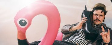 dumny viking na flamingu rozmawia przez dmuchaną atrapę telefonu prezentując internet na wakacje