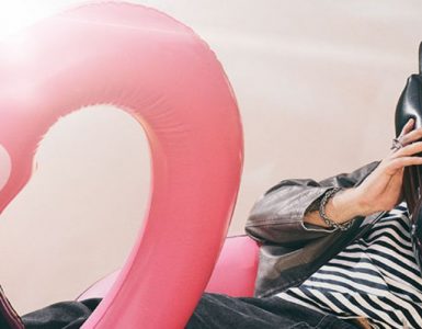 dumny viking na flamingu rozmawia przez dmuchaną atrapę telefonu prezentując internet na wakacje