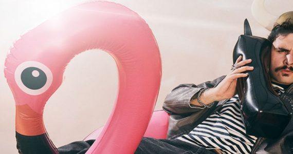 dumny viking na flamingu rozmawia przez dmuchaną atrapę telefonu prezentując internet na wakacje