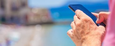 męska dłoń i telefon na wakacjach – bohater sprawdza limit danych w roamingu