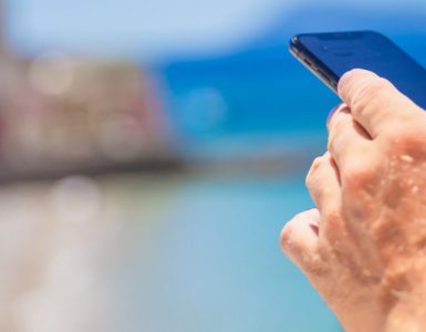 męska dłoń i telefon na wakacjach – bohater sprawdza limit danych w roamingu