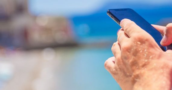 męska dłoń i telefon na wakacjach – bohater sprawdza limit danych w roamingu